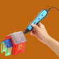 3D printing pen being used to create small models on a white background